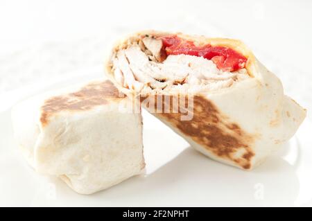 Un panino di shawarma yummy con pollo e pomodori nel sfondo bianco Foto Stock