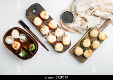 Involtini di sushi giapponesi denominati EBI al forno con wasabi e pesce di salmone set, su sfondo di pietra bianca, vista dall'alto piatto Foto Stock