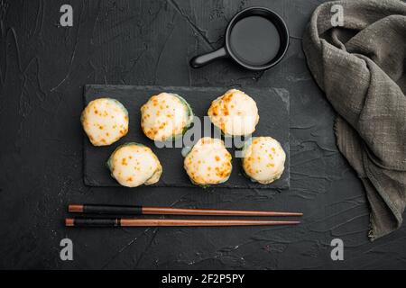 Panini giapponesi di sushi denominati EBI al forno con wasabi e pesce di salmone insieme, su fondo di pietra nera, vista dall'alto piatto Foto Stock
