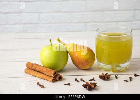 Succo di pera e mela con sapore cannella in una tazza di vetro Foto Stock