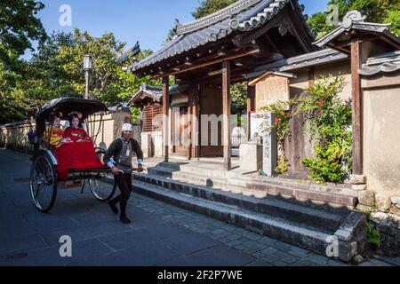 I turisti che cavalcano un risciò a Higashiyama vicino a Gion a Kyoto, Giappone Foto Stock