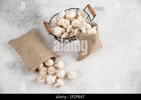 Funghi bianchi all'interno di cestini rustici e un vassoio metallico Foto Stock