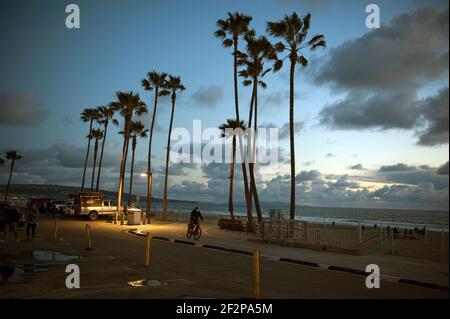 Cyclist mascherato su pista ciclabile a Manhattan Beach, California, al tramonto Foto Stock