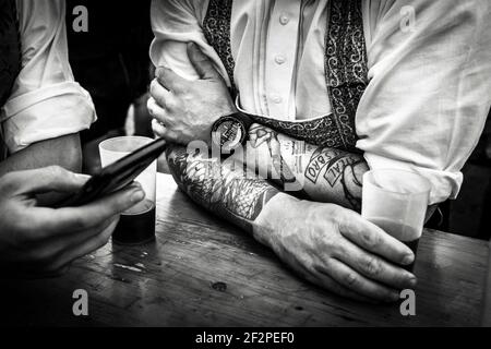 Germania, Baviera, Antdorf, settimana del festival dell'associazione dei costumi tradizionali. Uomo con tatuaggi sugli avambracci. Foto Stock