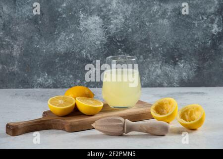 Una tazza di bicchiere di succo di limone fresco su un legno scheda Foto Stock