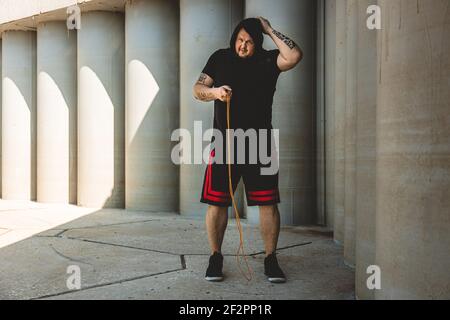 uomo caucasico combattente allenarsi duramente all'aperto.. Uomo che usa la corda, che fa il warm up. Concetto di sport e pugilato Foto Stock