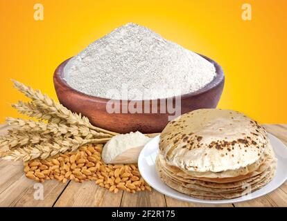 Farina di grano mazzo di spighe di grano, grani essiccati in ciotola di legno, farina in ciotola di legno su fondo bianco. Raccolta di cereali, prodotti da forno Foto Stock