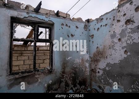 DISTRETTO DI AGDAM, AZERBAIGIAN - DICEMBRE 14: Interno di una casa parzialmente distrutta dopo che è stato colpito il 13 ottobre da un razzo sparato dalle forze armene nel villaggio di Quzanli il 14 2020 dicembre a Jabrayil Rayon di Azerbaigian. Alla fine di settembre sono scoppiati pesanti scontri sul Nagorno-Karabakh, durante i quali sono state uccise più di 5,600 persone, tra cui civili. Le parti hanno concordato un accordo di cessate il fuoco negoziato dalla Russia che ha avuto effetto il 10 novembre, con il risultato che l'Azerbaigian ha riguadagnato il controllo su fasce di territorio che gli armeni etnici avevano amministrato per quasi 30 anni. Foto Stock