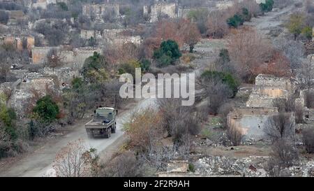 AGDAM, AZERBAIGIAN - DICEMBRE 14: Un camion militare azero guida attraverso la città fantasma di Agdam che è stato distrutto dalle forze armene durante la prima guerra di Nagorno-Karabakh il 14 dicembre 2020 ad Agdam, Azerbaigian. La città e il suo distretto circostante sono stati restituiti al controllo azerbaigiano come parte di un accordo che ha concluso la guerra di Nagorno-Karabakh 2020. Foto Stock