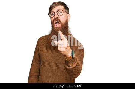 Giovane irlandese rosso uomo che indossa abiti casual e occhiali puntando dispiaciuto e frustrato alla macchina fotografica, arrabbiato e furioso con voi Foto Stock