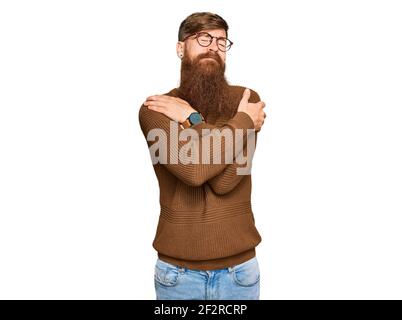 Giovane irlandese rosso uomo che indossa abiti casual e bicchieri abbracciandosi felice e positivo, sorridente sicuro. Auto amore e cura di sé Foto Stock