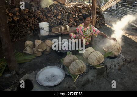 Yunce Unbanu palma bollente sap su boschi di fuoco nel villaggio di Oehandi, Rote Island, Indonesia. È in procinto di produrre zucchero di palma, una fonte alternativa di reddito per gli abitanti di un villaggio che vivono nell'isola. Foto Stock