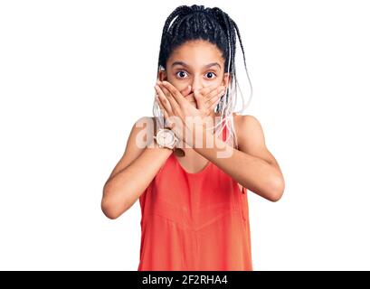 Carino african american ragazza indossando abiti casual scioccato coprendo la bocca con le mani per errore. Concetto segreto. Foto Stock