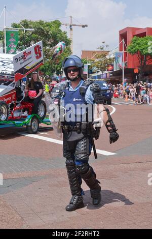 Un poliziotto neozelandese in equipaggiamento da sommossa (casco, corazza e scudo) che partecipa a una sfilata. Tauranga, Nuova Zelanda Foto Stock
