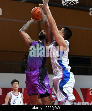 (210313) -- ZHUJI, 13 marzo 2021 (Xinhua) -- Troy Gillenwater (L) di Shandong Heroes spara su Ruoyu di Sichuan Blue Whales durante la 45° partita tra Shandong Heroes e Sichuan Blue Whales alla stagione 2020-2021 della Chinese Basketball Association (CBA) League a Zhuji, provincia di Zhejiang, 13 marzo 2021. (Xinhua/Hu Huhu) Foto Stock