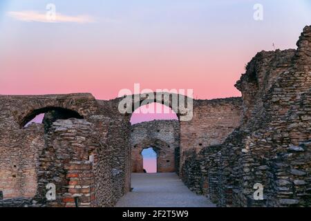 Rovine panoramiche ai raggi del tramonto delle Grotte di Catullo, villa romana nella città di Sirmione, Lago di Garda, Italia. Periodo invernale. Foto Stock