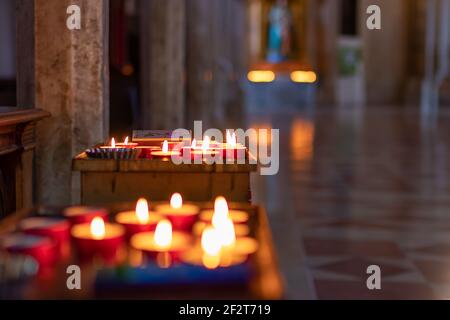 Candele bruciate nella Cattedrale di Santa Maria Assunta a Todi, Umbria, Italia. Messa a fuoco selettiva. Bokeh. Foto Stock