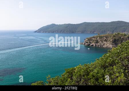 Bella vista mare o il mare smeraldo dell'isola d'Elba in Toscana con un motoscafo che attraversa l'orizzonte. Isola d'Elba, Toscana, Italia Foto Stock