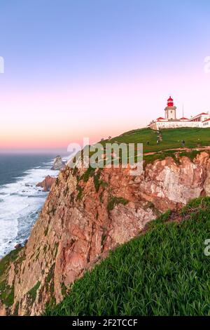 Cabo da Roca, Sintra, Portogallo. Faro e scogliere sull'Oceano Atlantico, il punto più occidentale della terraferma europea al tramonto. Foto Stock