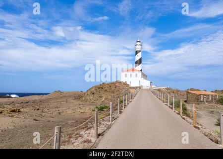 Vista del faro (Faro de Favaritx) in tempo soleggiato con belle nuvole nel cielo sull'isola di Menorca, isole Baleari, Spagna Foto Stock