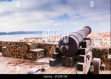 Antico cannone di bronzo di San Giorgio castello e panorama di Lisbona sullo sfondo in Portogallo Foto Stock