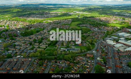 Foto aerea di una tipica proprietà immobiliare britannica nella grande città di Wigan, che mostra una vista dall'alto del drone di strade suburbane, strade e file di hous Foto Stock