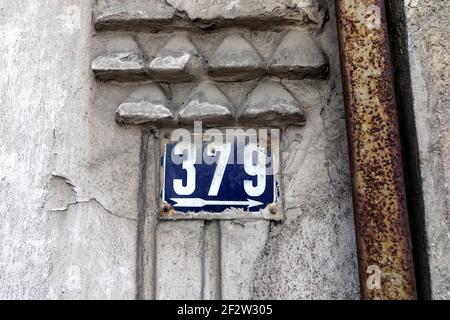 Numero 379 numero di case appartamenti strade. Numero bianco di lamiera blu casa numero trecentosettantanove (379) sulla parete ruvida Foto Stock