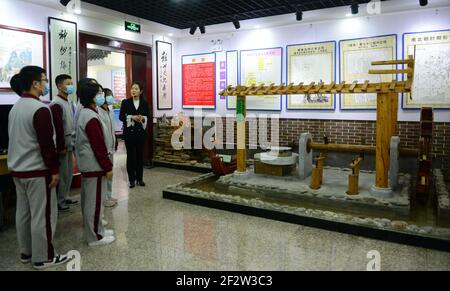 (210313) -- BAODING, 13 marzo 2021 (Xinhua) -- UN insegnante presenta una mostra agli studenti in visita presso la Sala commemorativa di Zu Chongzhi presso la Scuola superiore di Zu Chongzhi nella contea di Laishui, nella provincia di Hebei nella Cina settentrionale, 13 marzo 2021. Il 14 marzo è celebrato in tutto il mondo come Pi Day, poiché 3, 1 e 4 sono le prime tre cifre significative della costante matematica che denota il rapporto tra la circonferenza di un cerchio e il suo diametro. Zu Chongzhi, matematico e astronomo cinese del V secolo, aveva fatto un risultato notevole determinando il valore di Pi con una precisione di se Foto Stock