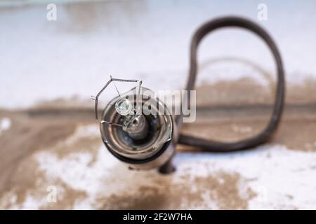 una lampadina esplosa in un primo piano della presa elettrica. Concetto di elettricità, problemi di illuminazione. Foto Stock