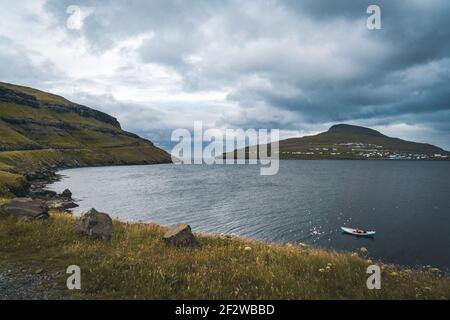 Due barche tradizionali con pescatore in un porto naturale, Faroe Island Foto Stock