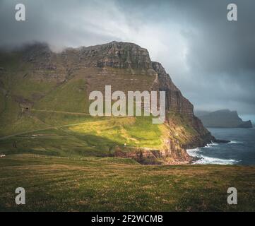 Isole Faroe con vista tempestosa verso mykines e l'oceano atlantico sull'isola di Vagar vista dalla cascata di mulafossur. Nuvole basse con atlantico Foto Stock