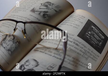 Il lettore è stanco; ha tenuto gli occhiali sul libro. Foto Stock