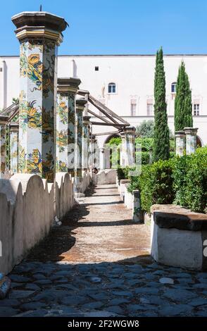 Vecchie colonne rivestite con cherammik e dipinte con motivi floreali in un cortile interno circondato da edifici Foto Stock