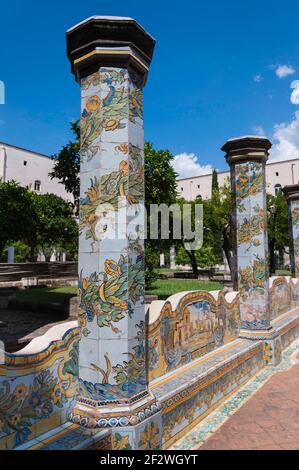 Vecchie colonne rivestite con cherammik e dipinte con motivi floreali in un cortile interno circondato da edifici Foto Stock