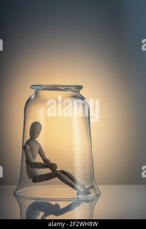 Corona virus - stare a casa, auto-isolamento, auto-quarantena. Un bell'uomo autoisolato si siede da solo in un pallone di vetro Foto Stock