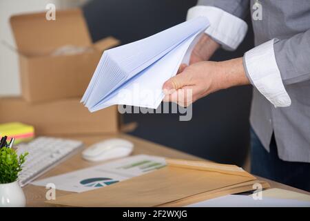 mani tagliate di uomo d'affari con buste Foto Stock