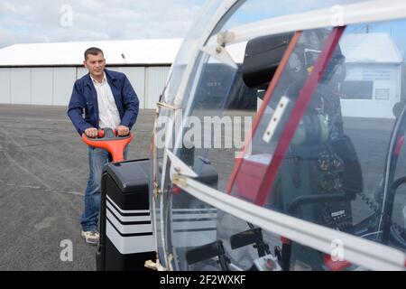 meccanico che utilizza transpallet elettrico per spostare aeromobili leggeri Foto Stock