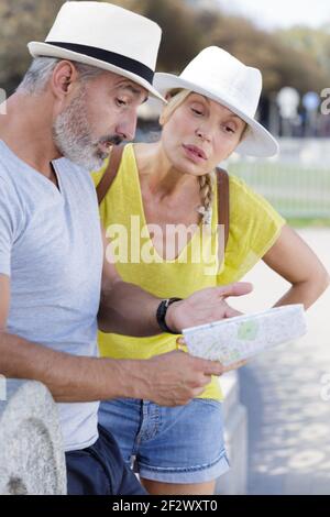 la coppia turistica anziana ha perso avendo un argomento con la mappa Foto Stock