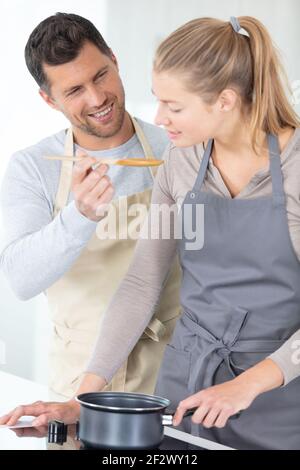 coppia che fa la pizza in cucina insieme Foto Stock