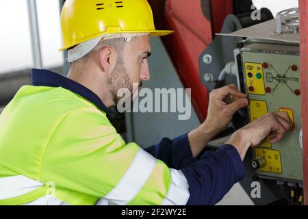 il lavoratore industriale lavora la macchina Foto Stock