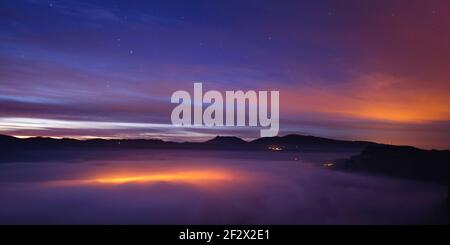 Mare notturno di nuvole sul villaggio di Vilanova de Sau. Vista dalla cima della Roca del Migdia (Osona, Catalogna, Spagna) Foto Stock