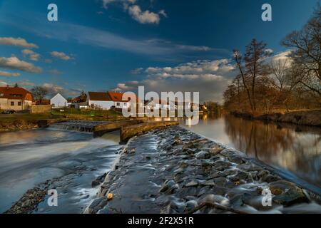 Big weir sul fiume Moldava a Roznov parte di Budweis città in inverno primavera tramonto colore sera Foto Stock