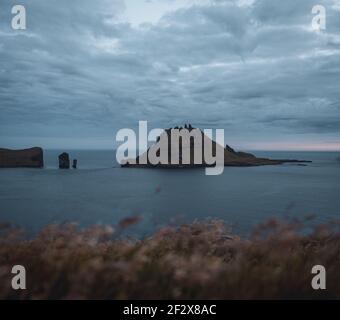 Foto ravvicinata della famosa scogliera di Drangarnir con le isole Tindholmur lo sfondo preso durante l'escursione di mattina presto in primavera a. Costa Faroese Foto Stock