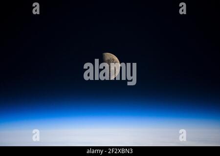 La Luna dell'ultimo quarto sopra l'orizzonte della Terra visto dalla Stazione spaziale Internazionale in orbita a 262 miglia sopra il 5 marzo 2021 in orbita terrestre. La Luna dell'ultimo quarto è il punto preciso della Luna che parade il Sole sull'arco finale del processo lunare. Foto Stock