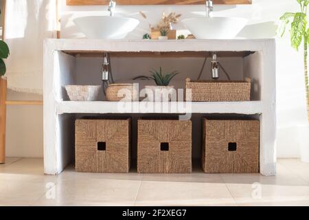 Dettagli del moderno e accogliente bagno interno bianco con box in vimini Foto Stock