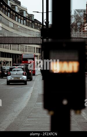 Londra UK Febbraio 2021 ingorgo nel centro di londra, più auto si allineano dietro un autobus della città di Londra. Contorno sfocato di un testo che dice 'aspetta' Foto Stock