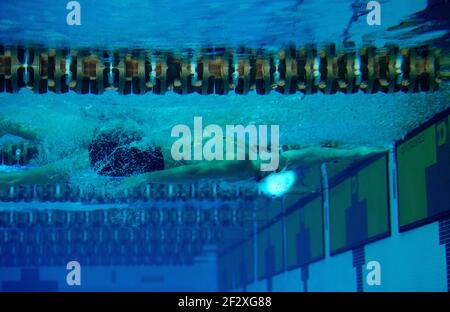 Un nuotatore maschile a corsa di ritorno nuota sott'acqua al turn in una piscina olimpionica. Foto Stock