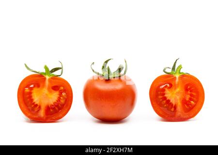 Pomodoro intero e due metà di pomodori isolati su bianco Sfondo Foto Stock