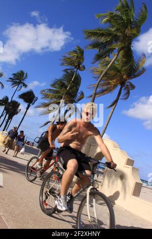 Giovani uomini in bicicletta sull'Hollywood Beach Broadwalk a Hollywood, Florida. Foto di Sean Drakes/Alamy Foto Stock