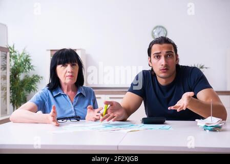 Donna ritirata e suo figlio giovane nel concetto di pianificazione del bilancio Foto Stock